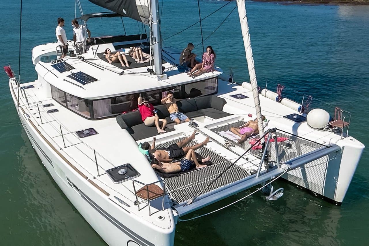 Des passagers se détendent sur les filets et le pont du Lagoon 450F Snitram.