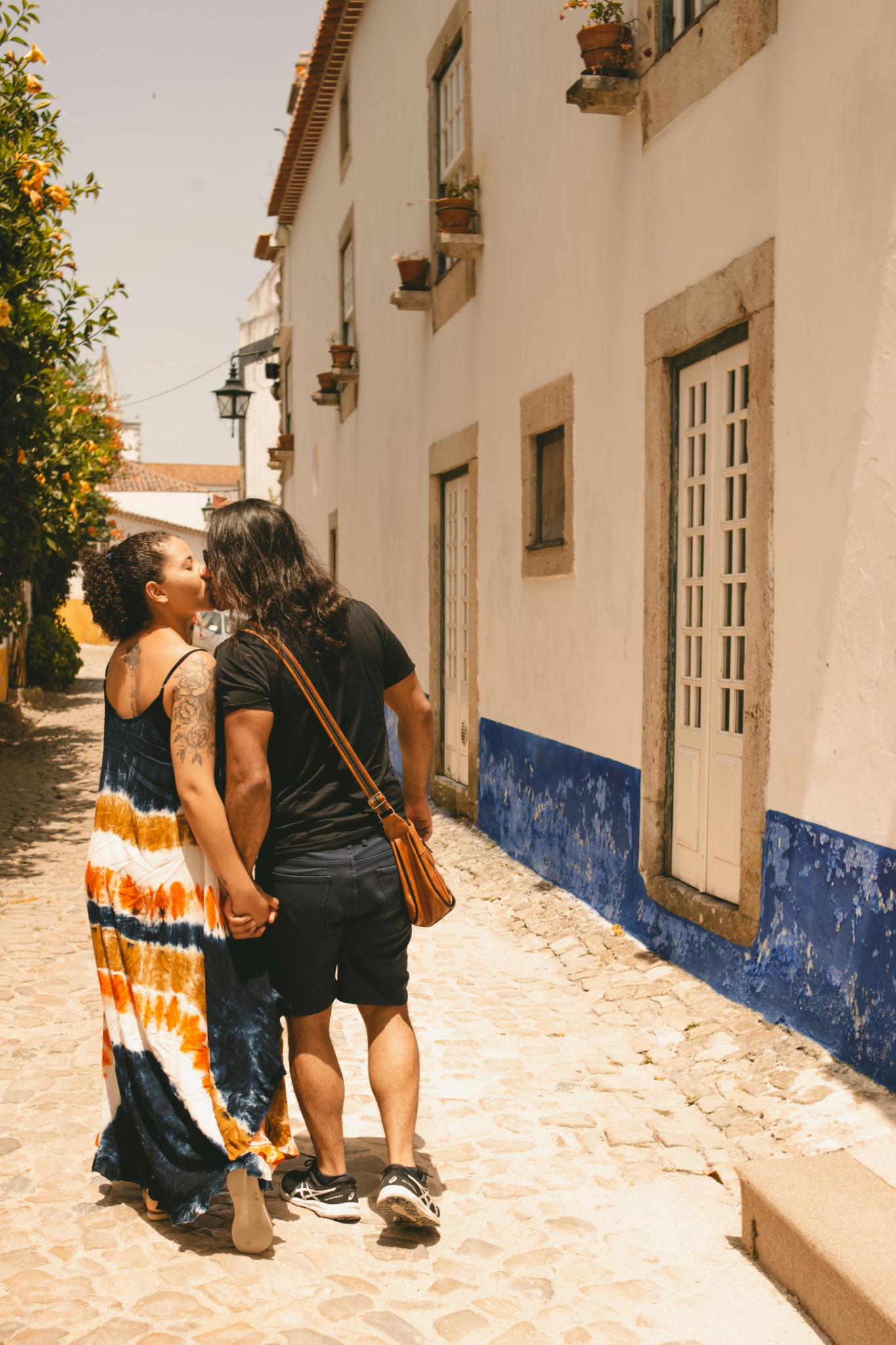Couple walking along a cobbled street in Portugal