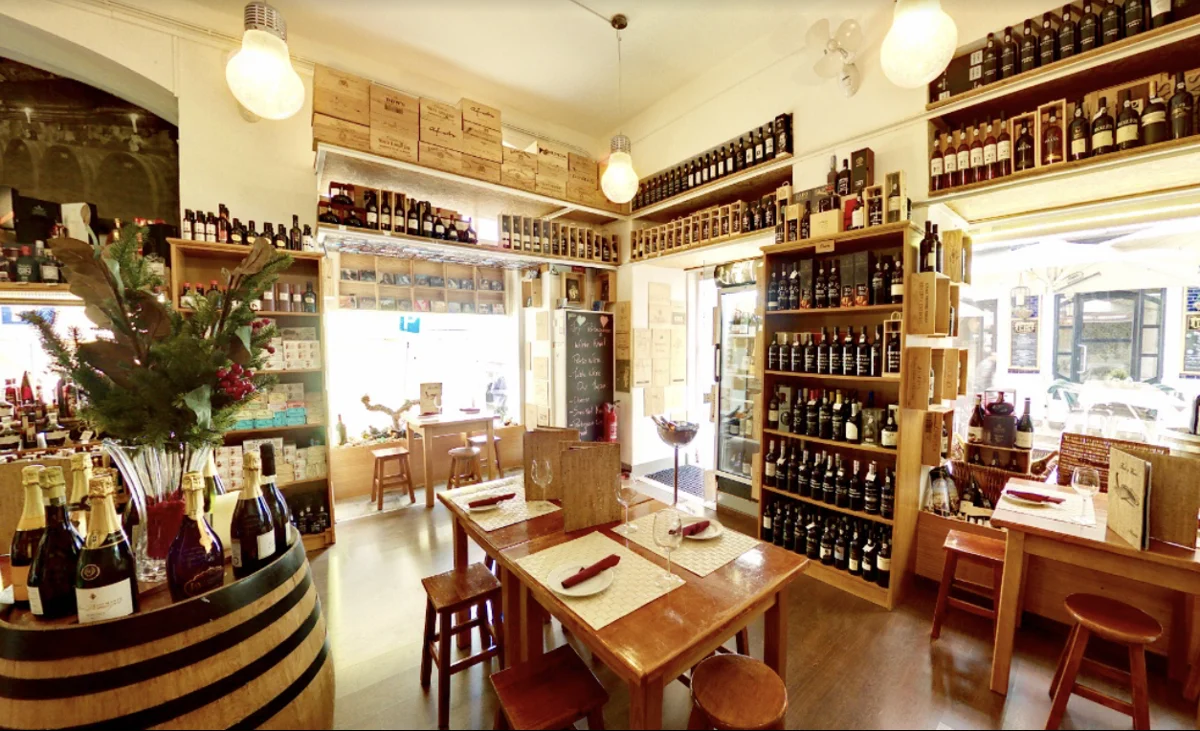 The dining room at Fado & Wine, with tables and wine bottles.